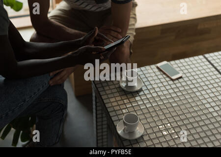 Couple using mobile phone in cafe Stock Photo