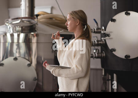Female worker talking on mobile phone in factory Stock Photo