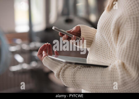 Female worker using mobile phone in factory Stock Photo