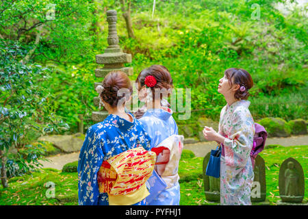 Kamakura, Japan - April 23, 2017: three women wearing in traditional japanese kimono inside Take-dera Temple garden in Kamakura. Japanese culture and lifestyle. Spring season. Stock Photo