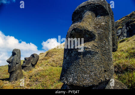 Two Maoi statues at angles on a hillside Stock Photo