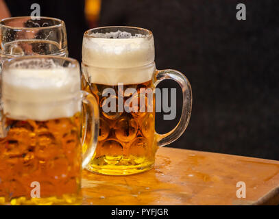 Mugs of Bavarian beer on a wooden desk, closeup view. Oktoberfest, Munich, Germany. Stock Photo