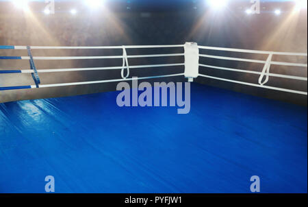 Boxing ring with blue flooring and white ropes. Professional arena for sport competitions and fighting tournaments Stock Photo