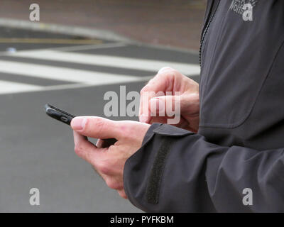 Closeup of Mans fingers using mobile phone at Leeds Bradford Airport Yeadon West Yorkshire England Stock Photo