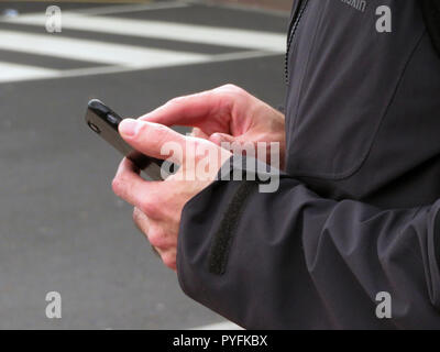 Closeup of Mans fingers using mobile phone at Leeds Bradford Airport Yeadon West Yorkshire England Stock Photo