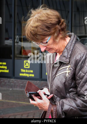Woman using mobile phone at Leeds Bradford Airport Yeadon West Yorkshire England Stock Photo