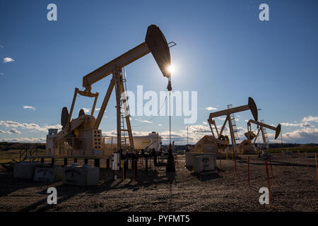 Trio of oil pumpjacks working north of Cochrane, Alberta Canada Stock Photo