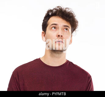 Positive male with attractive look, wearing T-shirt looking up Stock Photo