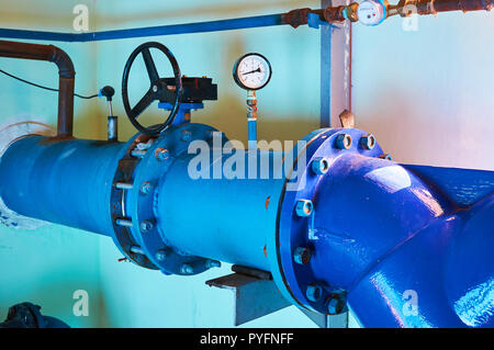 Gate valves installed on pipes painted in blue. Industrial background. Stock Photo