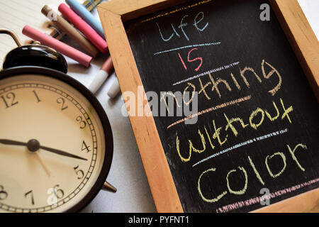 Life is nothing without color on phrase colorful handwritten on chalkboard, alarm clock with motivation and education concepts Stock Photo