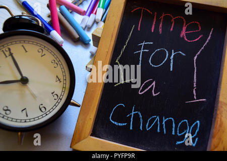 Time for a change on phrase colorful handwritten on chalkboard, alarm clock with motivation and education concepts Stock Photo