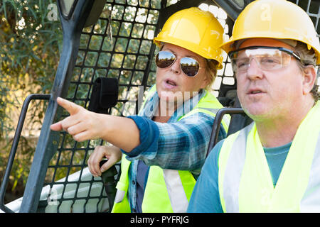 Male and Female Workers Talking at Construction Site Stock Photo