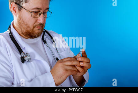 Medical doctor holding syring with in his hand and in a suit Stock Photo