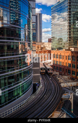 Two commuter trains crossing on curved elevated tracks in downtown Chicago Stock Photo