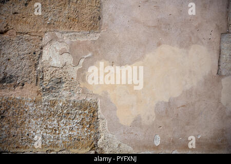 Faded plastered and stone masonry wall, texture grunge background. Stock Photo