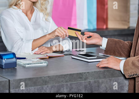 cropped shot of customer giving credit card to seller in shop Stock Photo