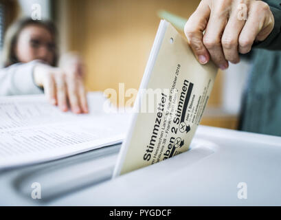 Frankfurt Main, Germany. 28th Oct, 2018. In the morning, a voter throws her ballot for the state elections in Hesse into the ballot box. Credit: Frank Rumpenhorst/dpa/Alamy Live News Stock Photo