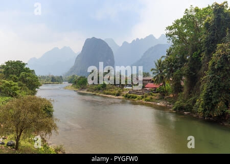 Scenic view of the Nam Song River, Pha Tang village and limestone mountains near Vang Vieng, Vientiane Province, Laos, on a sunny day. Stock Photo