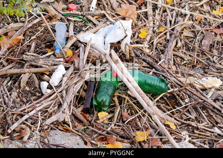 Plastic and glass bottles thrown away and left in nature, pile of garbage. Ecological, ecology, recycling industry, not ecology, recycled material. Stock Photo