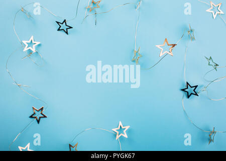 Golden star shaped garland on pastel blue background. Flat lay style. Christmas concept. Stock Photo