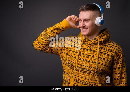 Happy young handsome man listening music with headphones Stock Photo