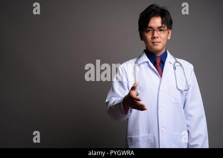 Portrait of young Asian man doctor giving handshake Stock Photo