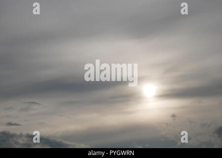 Gray moody clouds and the sun shines through the overcast Stock Photo