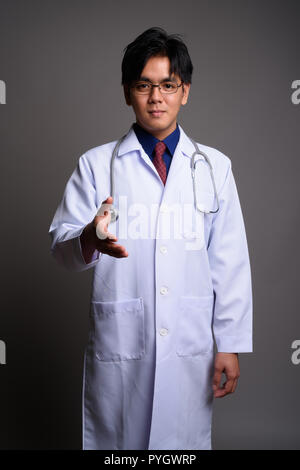 Portrait of young Asian man doctor giving handshake Stock Photo