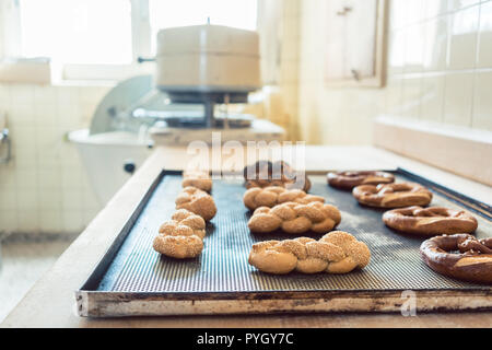 Bread rolls and pretzels on tray in bakery  Stock Photo
