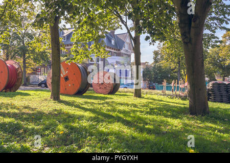 Hague, The Netherlands, October 05, 2018: Huge reels of cabel laying on the grass Stock Photo