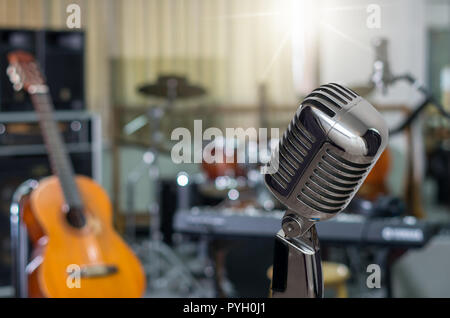 Retro Microphone over the Abstract blurred photo of music band instrument background, musical concept Stock Photo