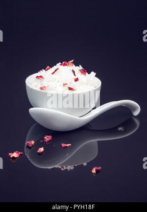 Bowl of white rice garnished with edible dried rose petals Stock Photo
