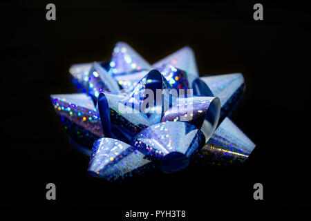 Christmas Hoiday Satin Light Blue Holographic Bow Ribbon. Light Blue in Color. On Black background. Room for copy. Vivid and clear. Stock Photo