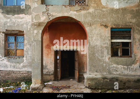 An old abandoned house with broken windows and cracks in the wall. Stock Photo