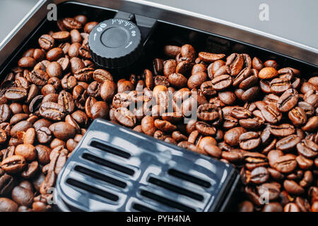 Coffee beans grinding in coffee machine grinder Stock Photo