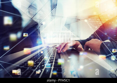 Business man works in office with laptop in the foreground. Concept of teamwork and partnership. double exposure with network effects Stock Photo