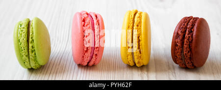 Sweet macarons on a white wooden background, side view. Closeup. Stock Photo