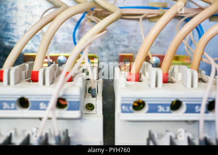 Two electric wires connected trozfaznyh switch on metal background. Stock Photo