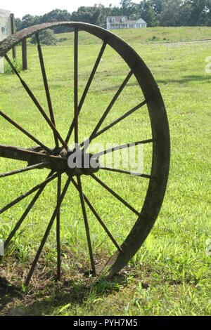Old rusty wheel from farm equipment in field in Virginia's countryside, USA Stock Photo