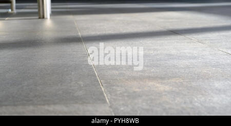 on the floor the sun's rays. The Shine of sunlight on pressed Sandstone paving slabs is an unusual perspective of photo paving slabs with a small depth of field in perspective. Stock Photo