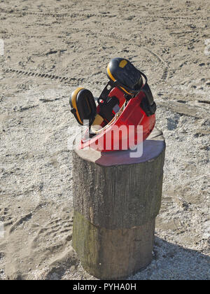 Safety helmet on log on beach Stock Photo