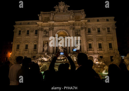 Sightseeing in Rome. Tourists visit and take pictures at the wonderful Trevi Foutain with night illumination Stock Photo
