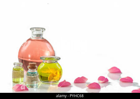 Rose flower petals with aromatherapy essential oil glass bottle isolated over white , background, copy-space Stock Photo