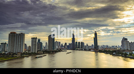 Cityscape of modern building near the river in the morning with grey and yellow sunrise sky and clouds. Modern architecture office building. Skyscrape Stock Photo