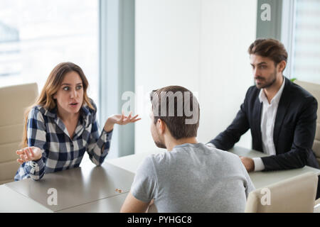 Unhappy young couple at meeting with lawyer about divorce Stock Photo