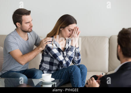 Young man, husband calming and supporting woman Stock Photo