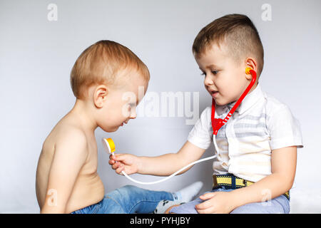 Two little boys using stethoscope. Children playing doctor and patient. Check the heartbeat. Stock Photo