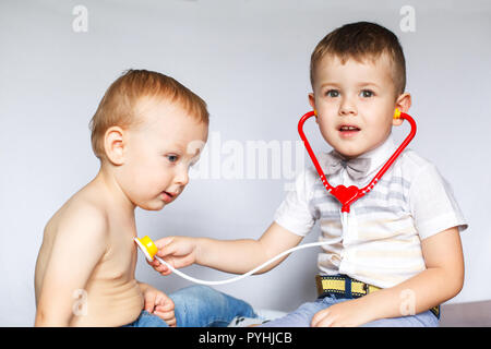 Two little boys using stethoscope. Children playing doctor and patient. Check the heartbeat. Stock Photo