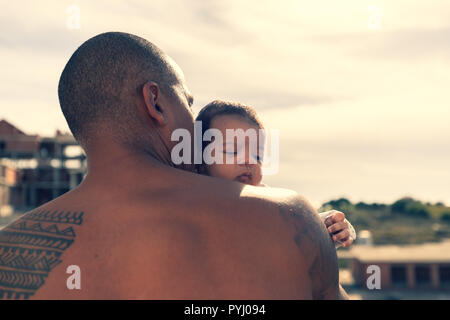 A 7 week old baby boy over the shoulder of his dad. Stock Photo