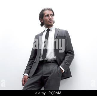 businessman is leaning on a white wall Stock Photo